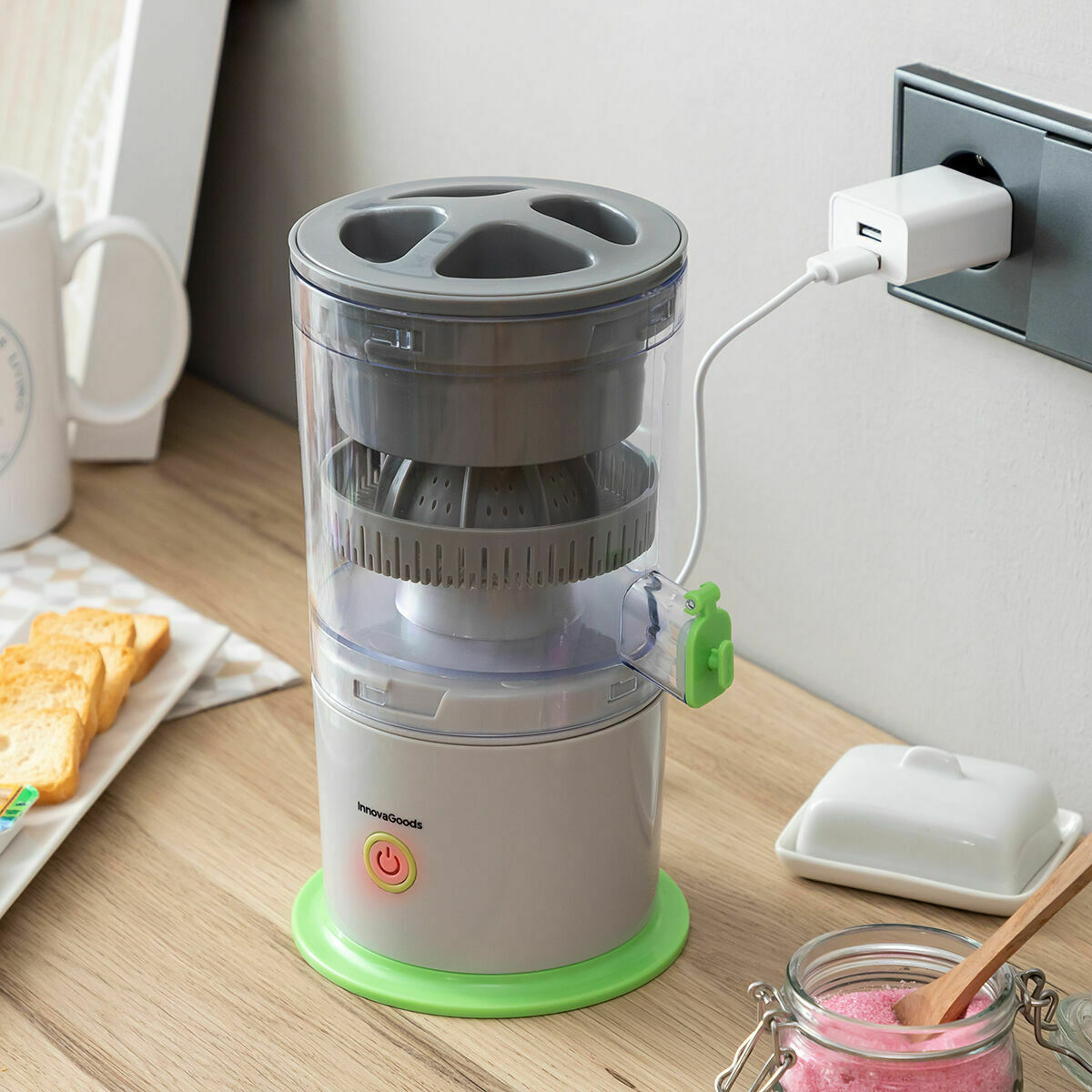 Juicer plugged into an outlet, charging with USB cable on a kitchen counter.