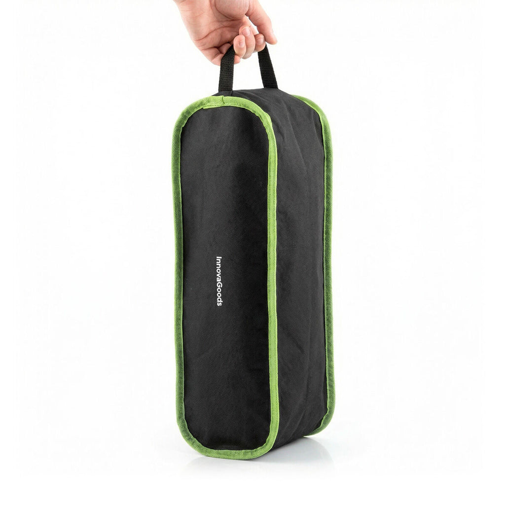 The carry bag is being held in a hand, showing its portability. It is black with green piping and sports the InnovaGoods branding.
